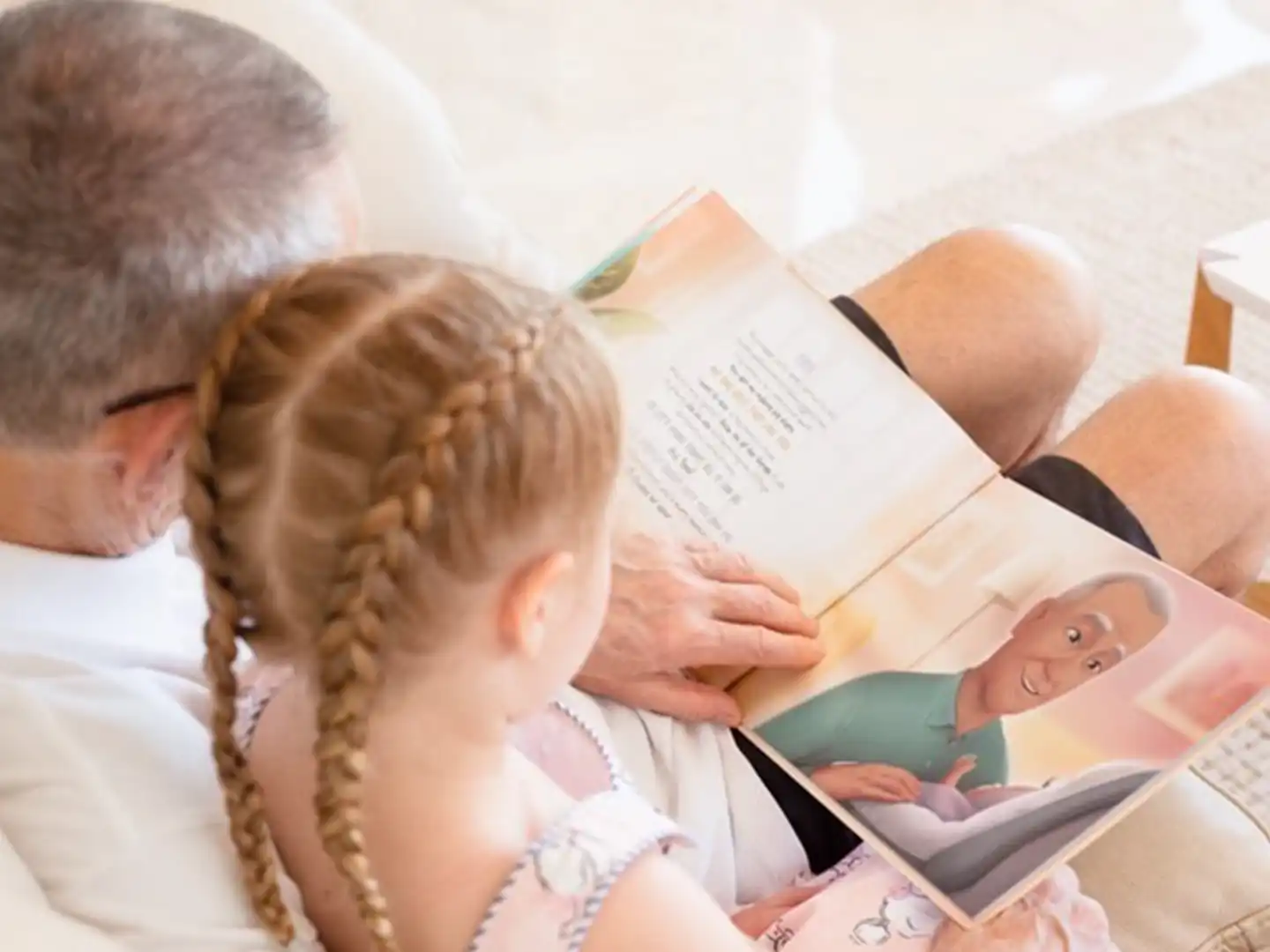 Ein Großvater und Enkeltochter blättern in ihrem personalisierten Buch für Opas, das beste Geschenk für jeden Opa. 